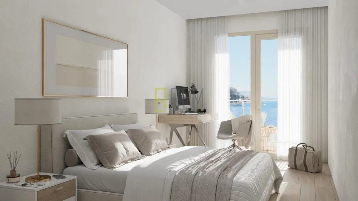 Bright and tidy bedroom with a double bed, a desk, and a sea view.