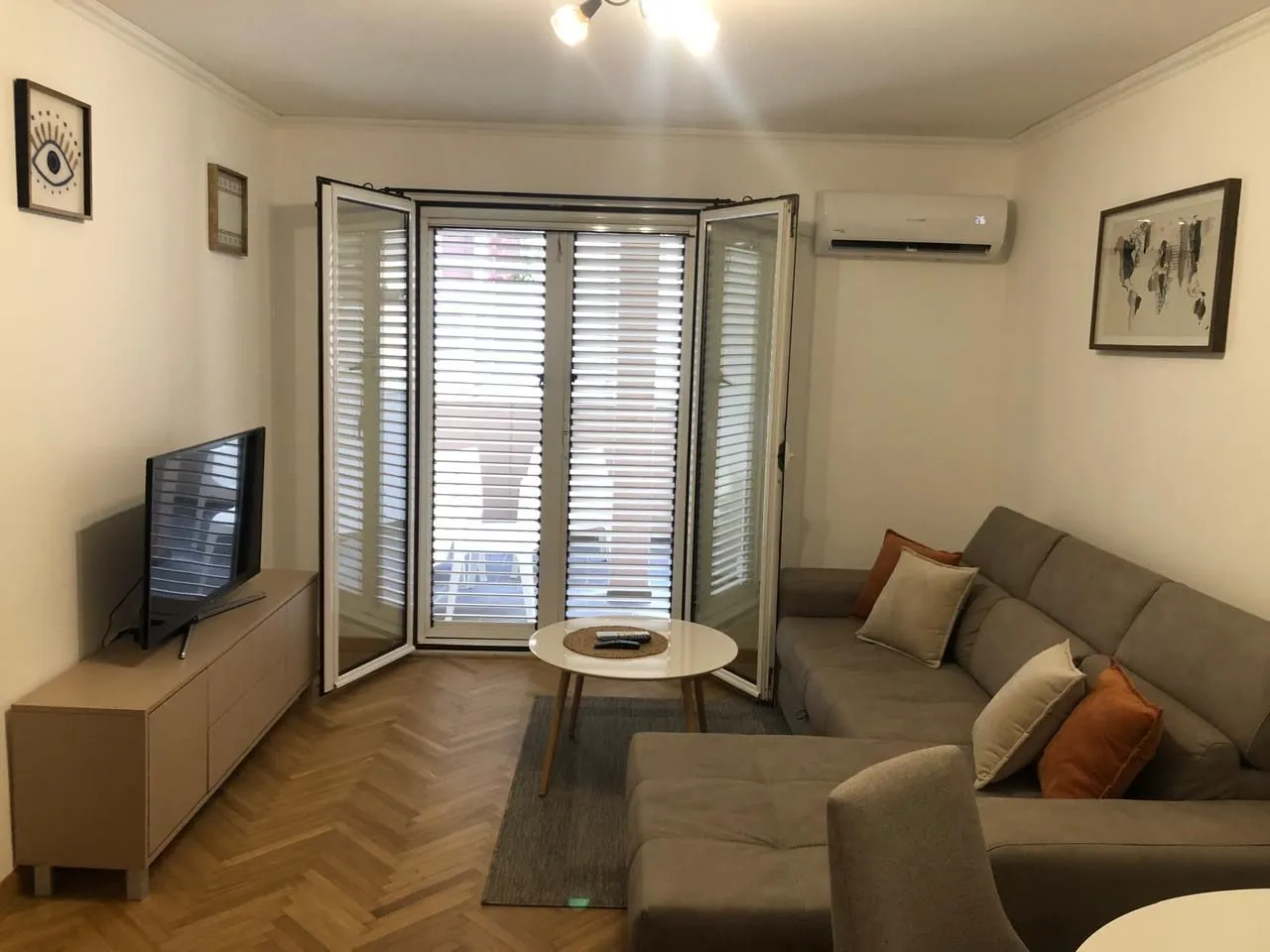 Living room with a sectional sofa, TV, and access to the terrace.