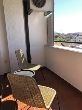 Terasa sa dvije pletene stolice i pogledom na grad. - image 14