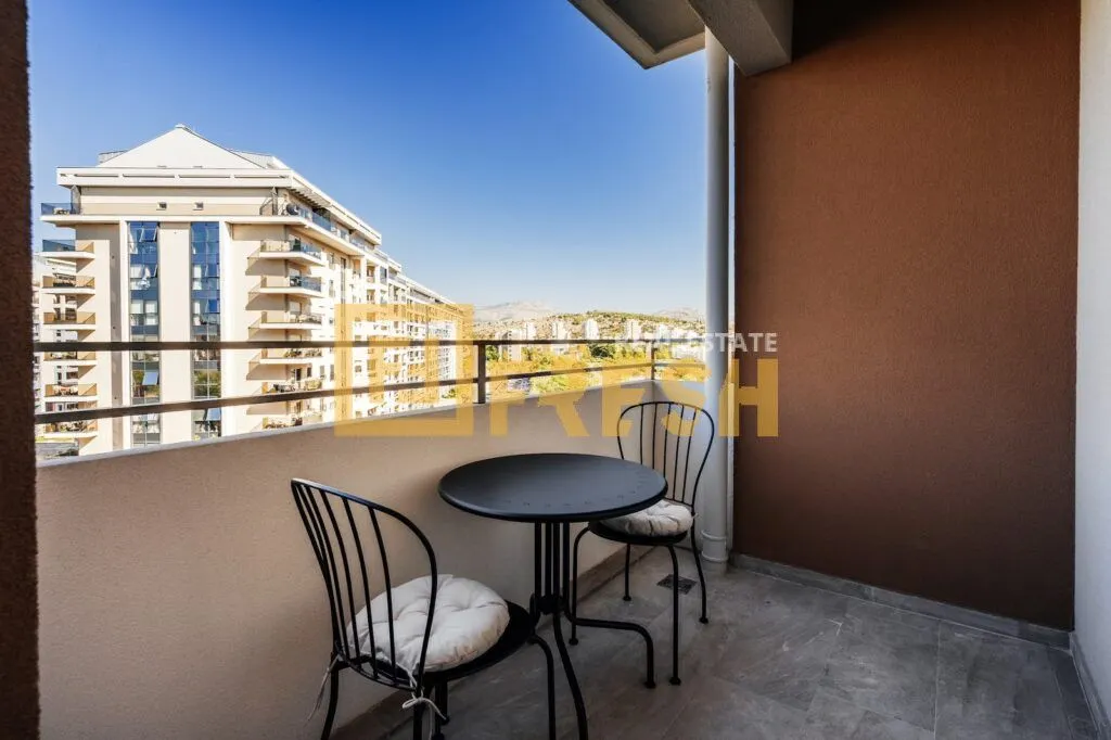 Covered balcony with outdoor seating and city views.
