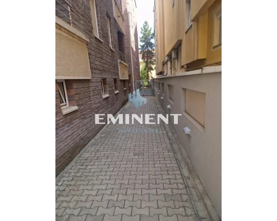 Paved passageway between buildings with exterior lighting.