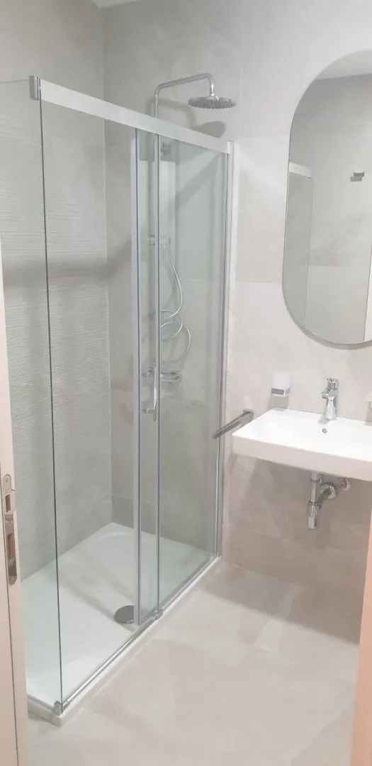 Modern bathroom with a glass shower cabin and a sink.