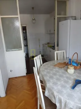 Dining area with a table and chairs and a view of the kitchen. - image 4