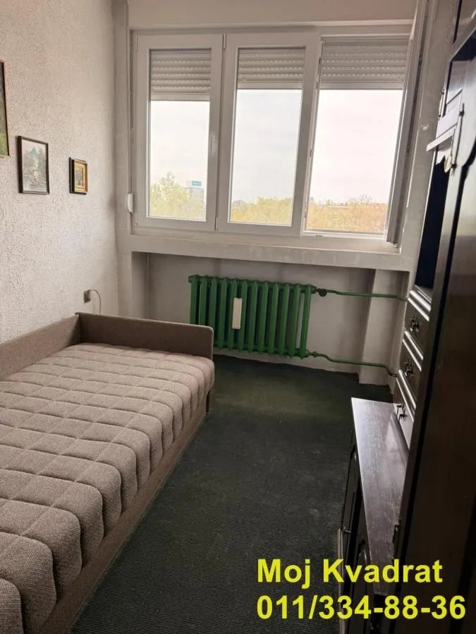Manja spavaća soba sa krevetom i prozorom.