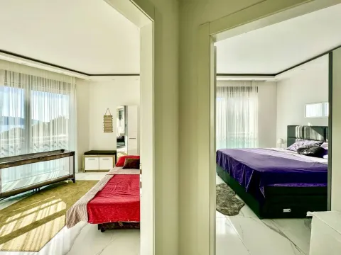 View through the doorway into a furnished bedroom with a large double bed. - image 10