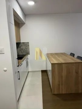 Moderna kuhinja sa belim elementima i trpezarijskim stolom. - image 10