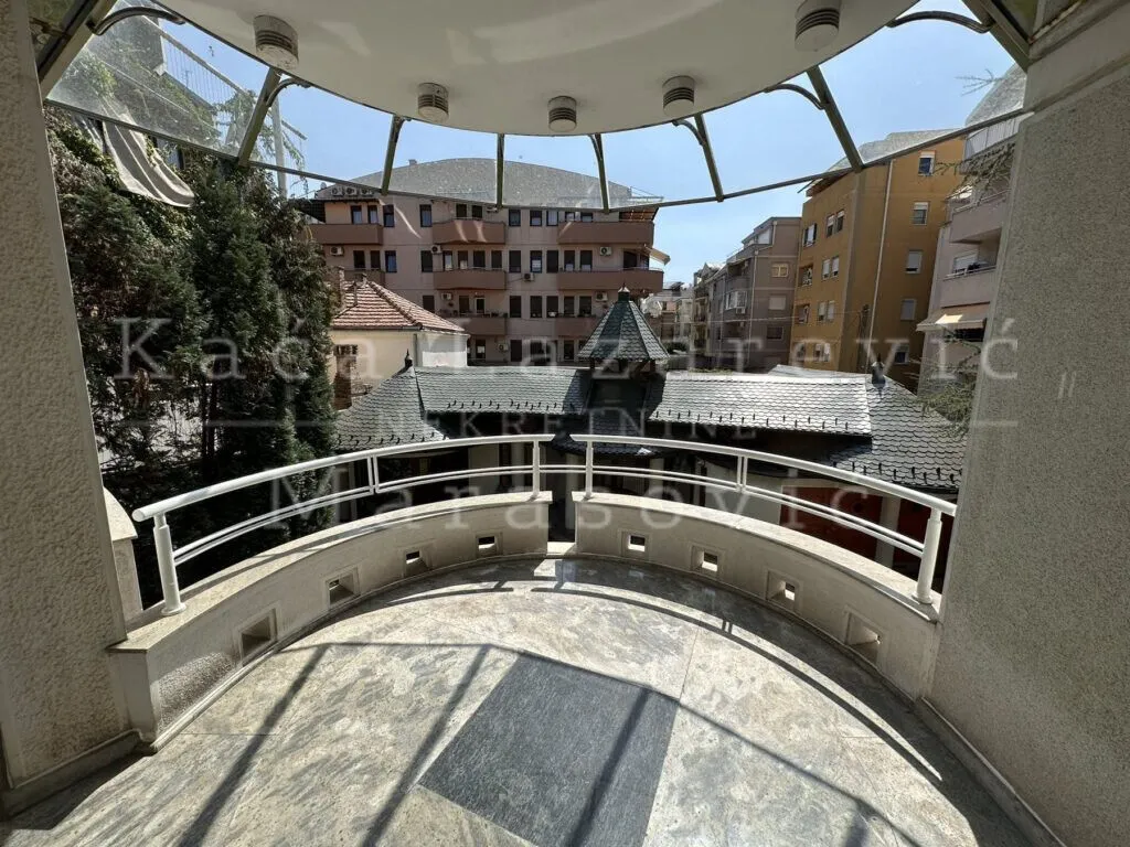 Prostrana polukružna terasa sa pogledom na okolne zgrade i naselje.