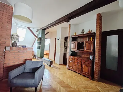 Living room with wooden furniture, brick fireplace, and exposed ceiling beams. - image 11