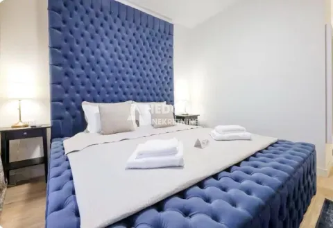 Bedroom with a large upholstered bed and bedside tables. - image 6