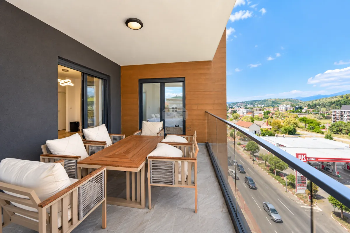 Spacious covered terrace with seating set and city view.