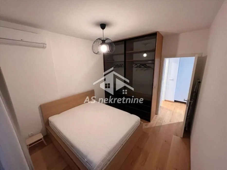 Bedroom with a double bed, large wardrobe, and air conditioning.