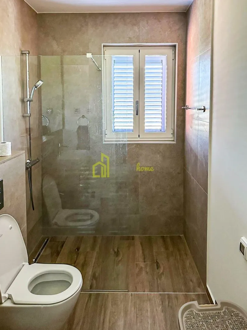 Moderne kupatilo sa tuš kabinom i prozorom.
