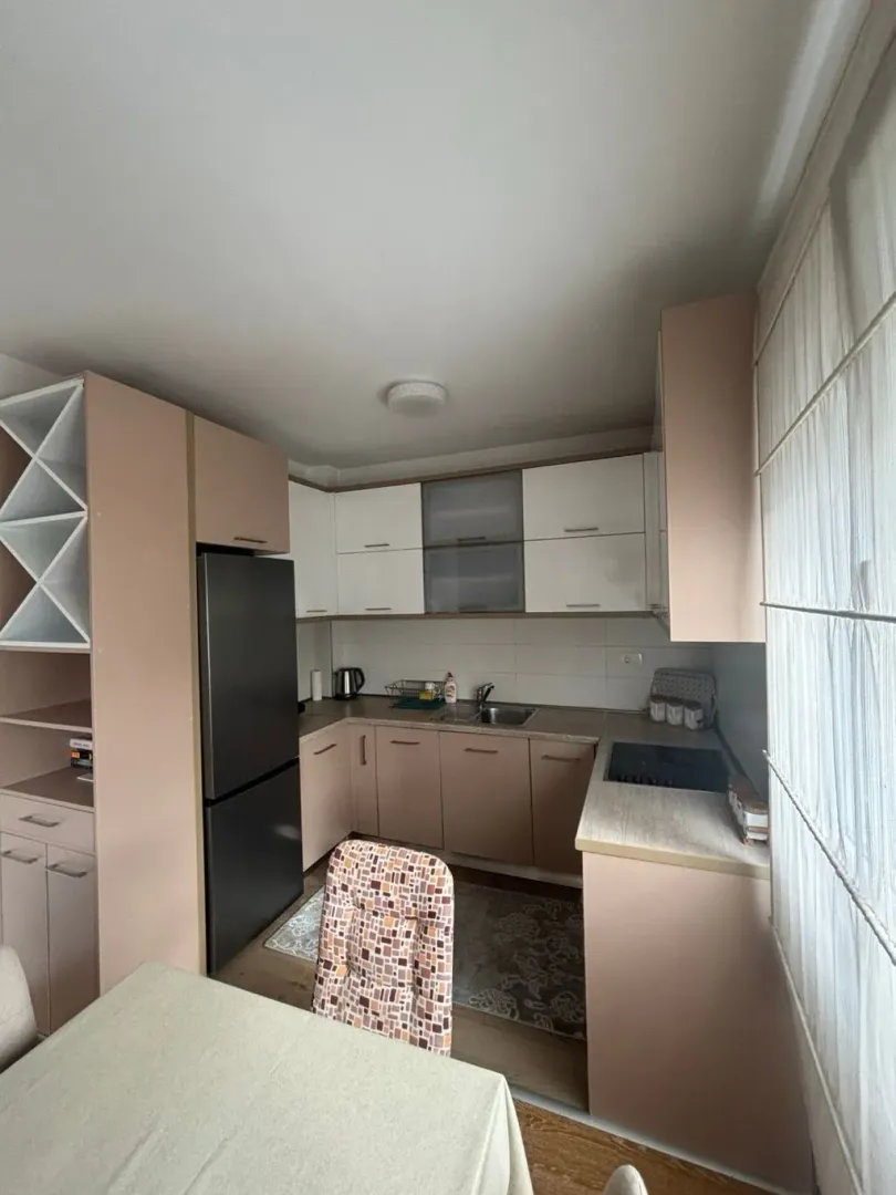 Smaller kitchen with wooden cabinets and a dark refrigerator.