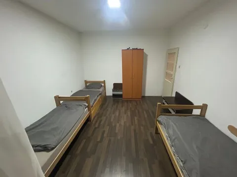 Furnished bedroom with three beds and a wardrobe. - image 2