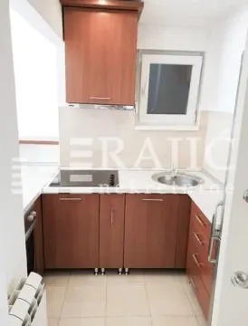 Small kitchen with wooden cabinetry and a window. - image 8
