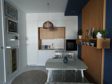 Modern kitchen with a dining table and decorative wooden panels. - image 5
