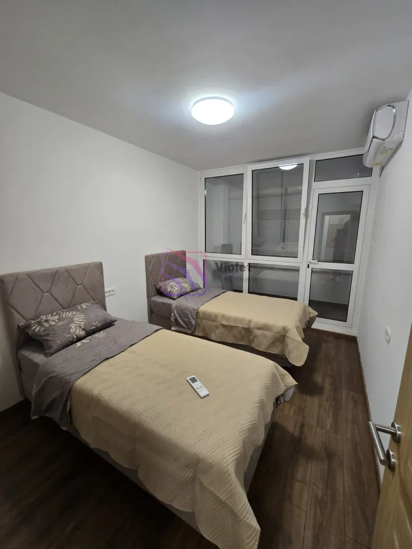 Spavaća soba sa dva singl kreveta i izlazom na terasu.