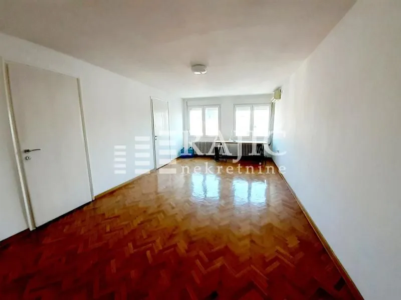 Empty room with parquet flooring and white walls.