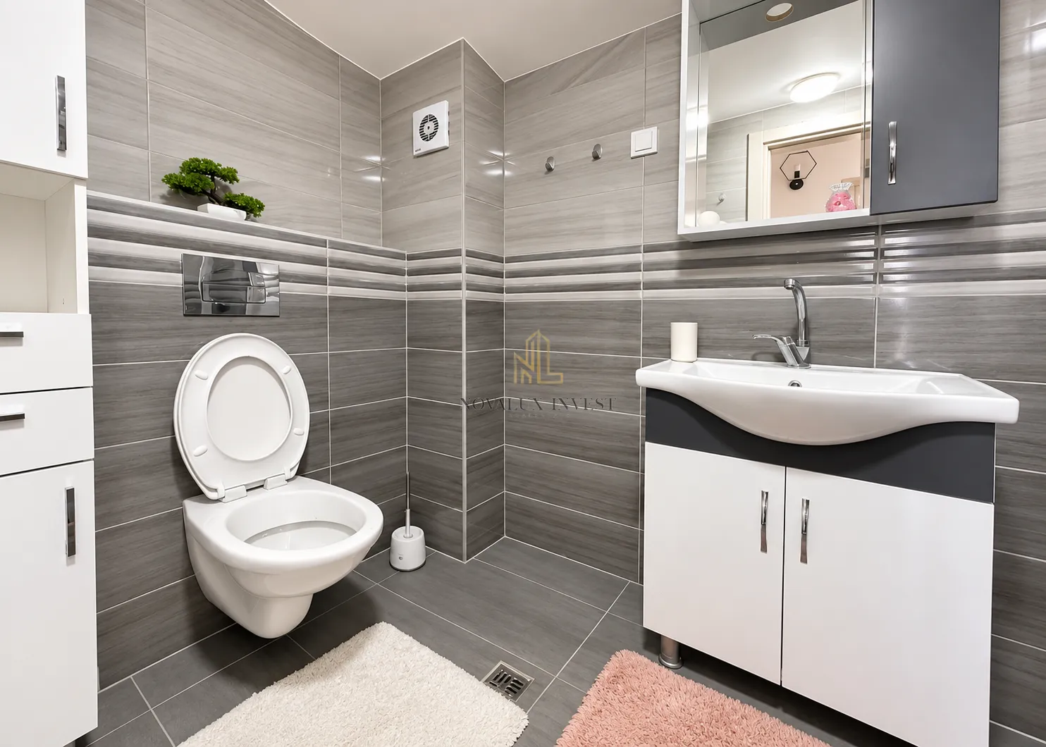 Moderno opremljeno kupatilo sa tuš kabinom, umivaonikom i wc šoljom.