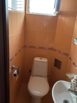 Manje kupatilo obloženo narandžastim pločicama sa WC šoljom i umivaonikom. - image 7