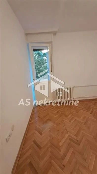 Empty room with wooden parquet flooring and access to the terrace.