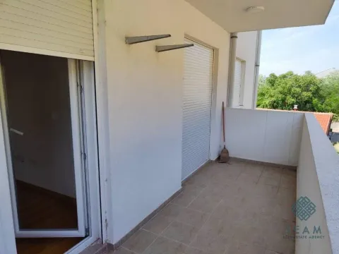 Nenamješten balkonski prostor sa keramičkim pločicama i roletnama na prozorima. - image 4
