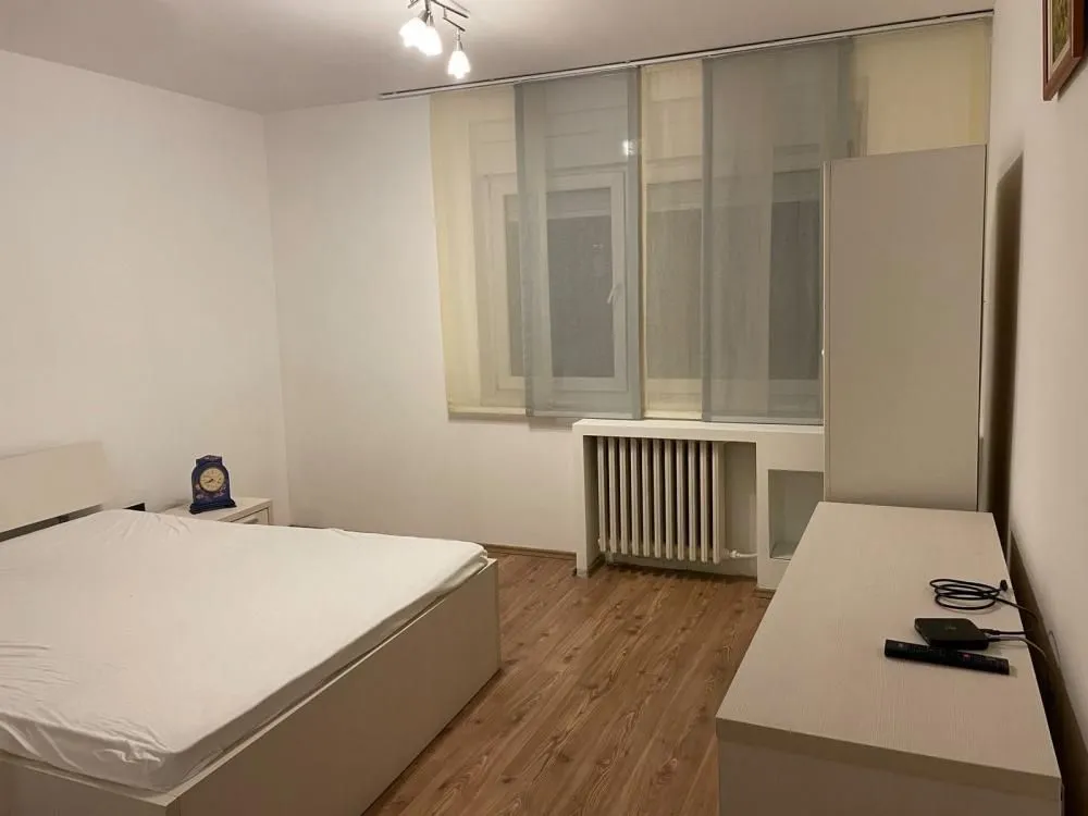 Furnished bedroom with a double bed, wardrobe, and chest of drawers.