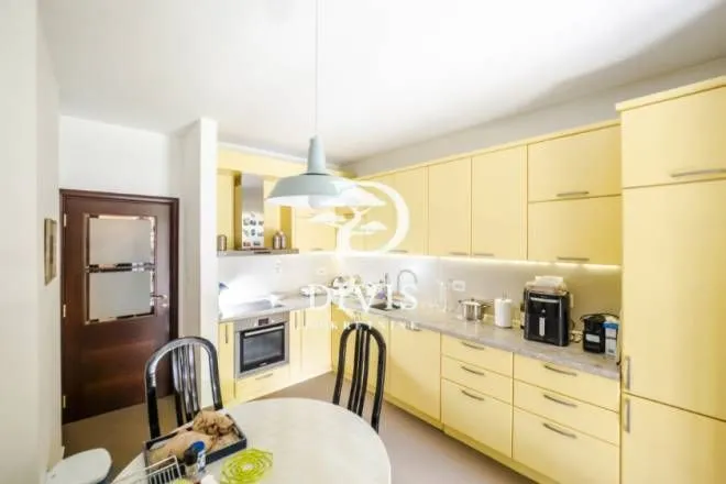 Kitchen with yellow cabinetry and a dining table.