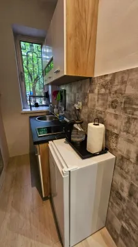 Small, functional kitchen with built-in cabinets and a mini fridge. - image 10