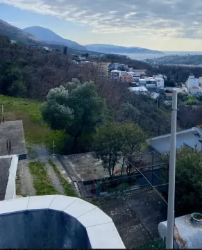 View from the terrace overlooking the settlement, greenery, and the sea in the distance. - image 7