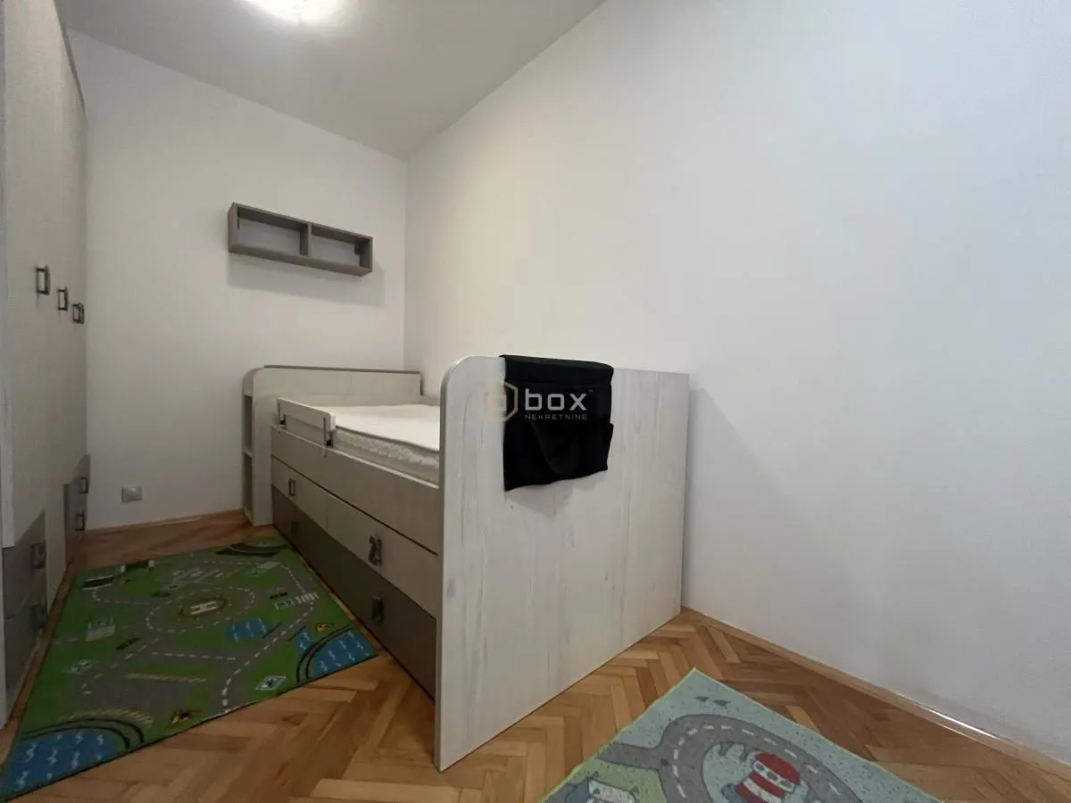 Children's bedroom with a bed and parquet flooring.