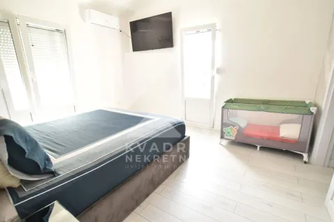 Bedroom with a double bed, air conditioning, TV, and a baby cot. - image 23