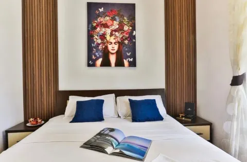 Furnished bedroom with a double bed, bedside tables and an artwork on the wall. - image 7