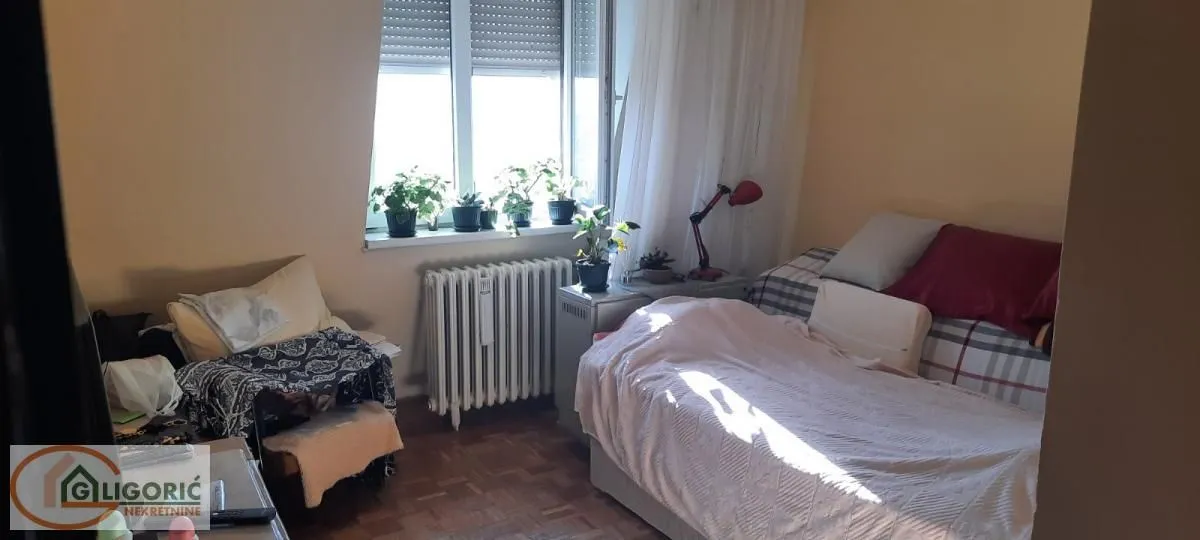 Nameštena spavaća soba sa krevetom i prozorom.