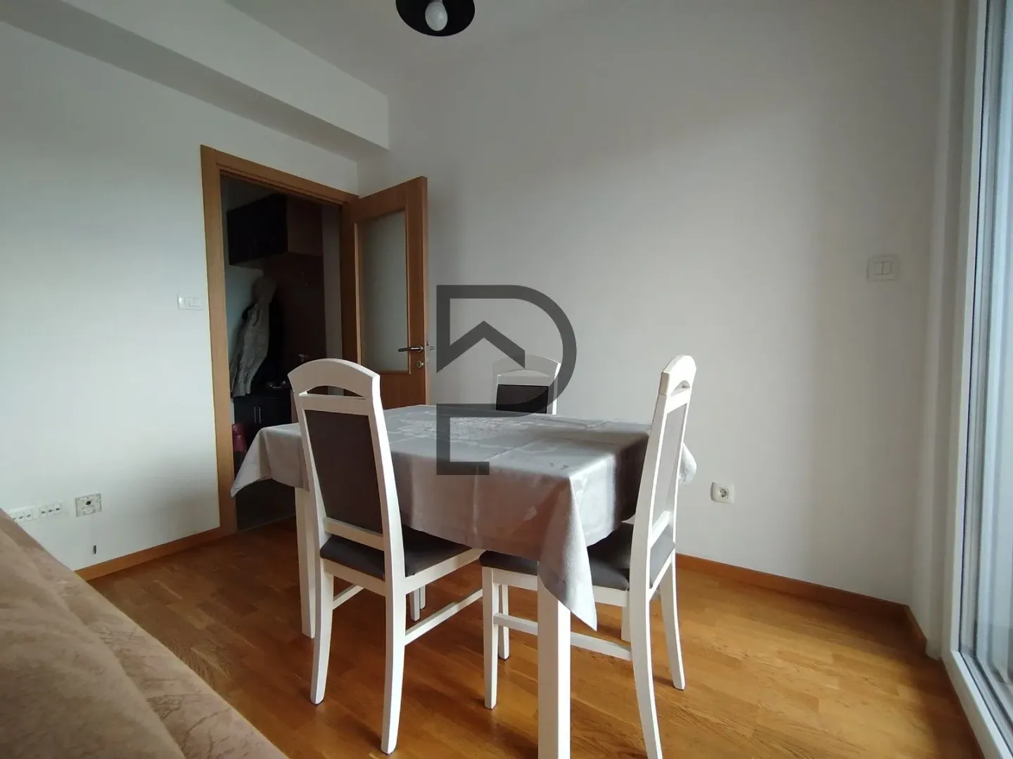 Dining area with a table and white chairs in a bright interior.