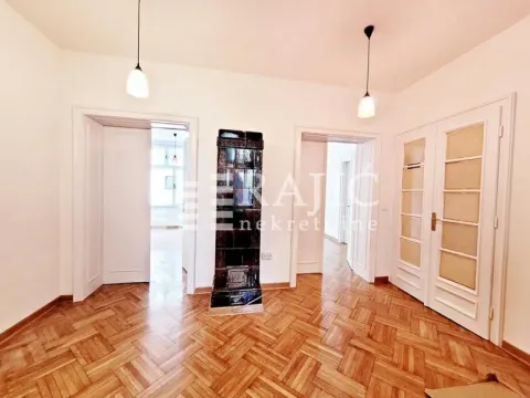 Empty room with parquet flooring and a wood-burning stove. - image 18