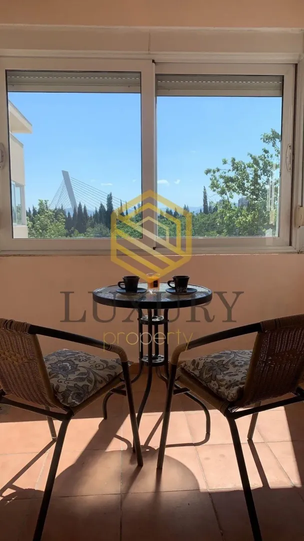 Furnished terrace with a table, chairs, and city view.