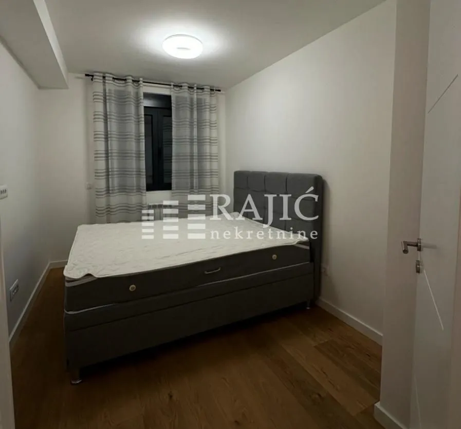 Furnished bedroom with a double bed and a window.