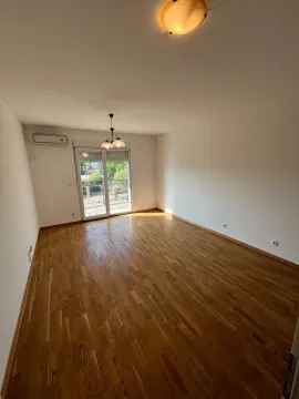 Prazna soba sa drvenim podom i izlazom na terasu. - image 3