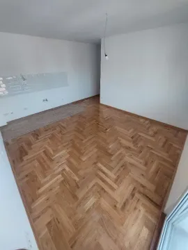Prazna soba sa parketom i priključcima za kuhinju. - image 4
