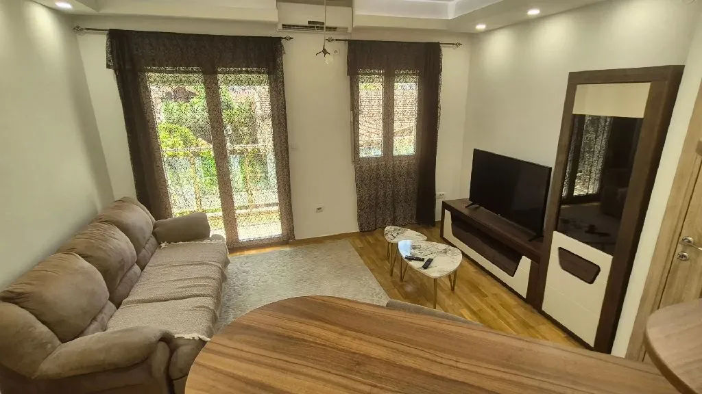 Namješten dnevni boravak sa garniturom i televizorom.