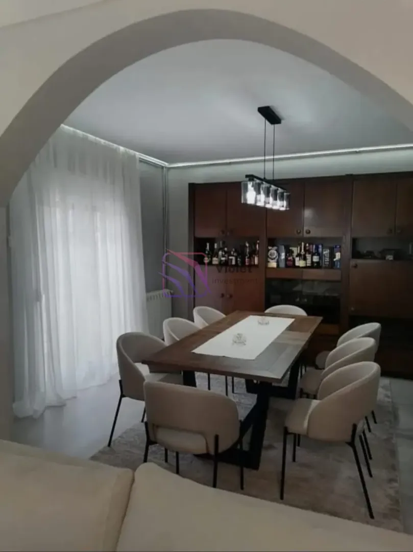 Dining area with a large table and chairs, connected to the living room.