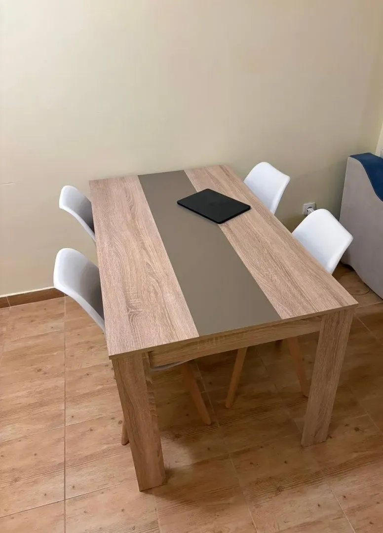 Trpezarijski sto sa četiri stolice u svijetloj prostoriji.