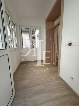 Enclosed balcony with wooden flooring and windows with a view. - image 4