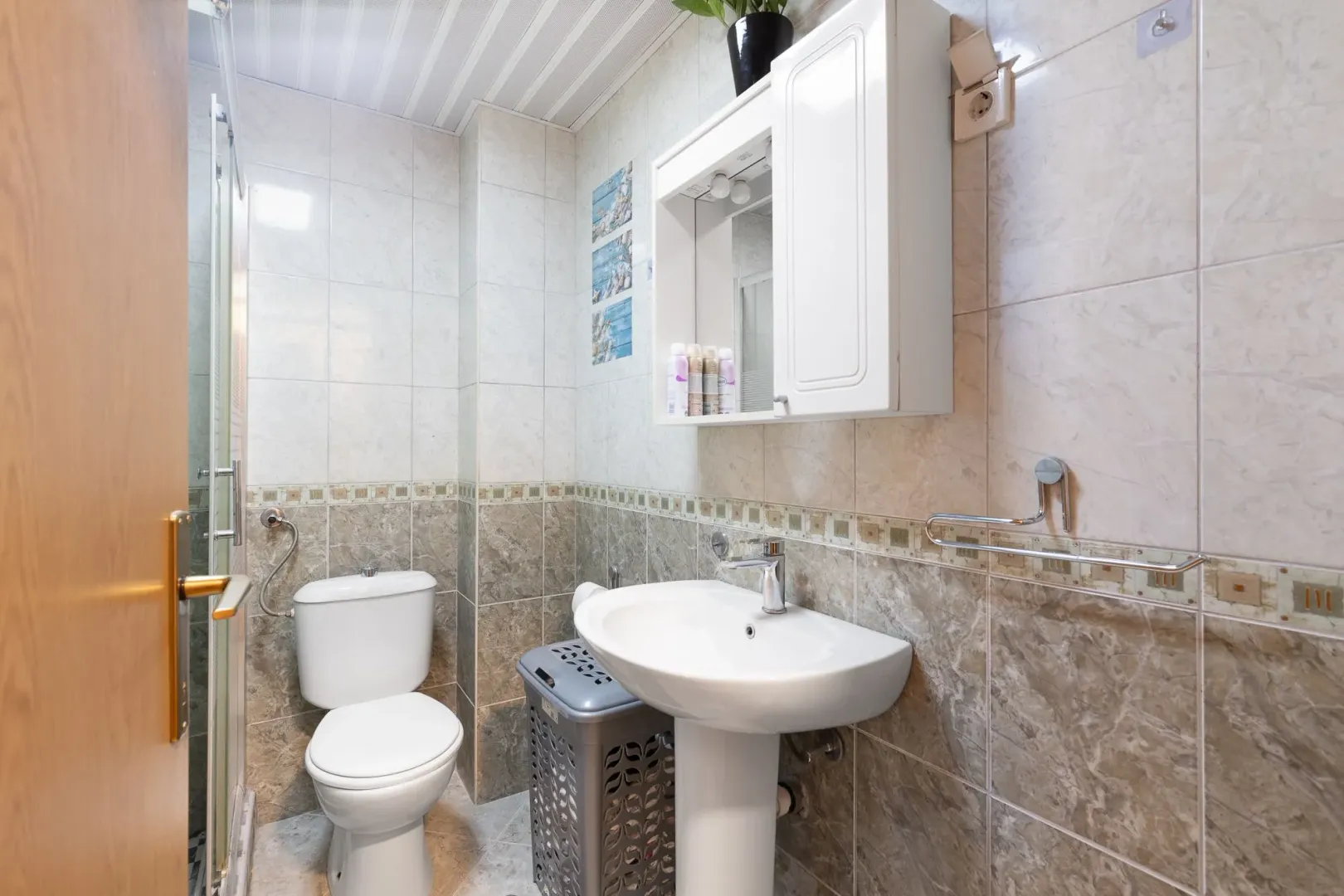 Small bathroom with a sink, toilet, and wall cabinet.
