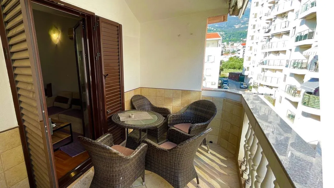 Furnished balcony with seating set and a view of the urban surroundings.