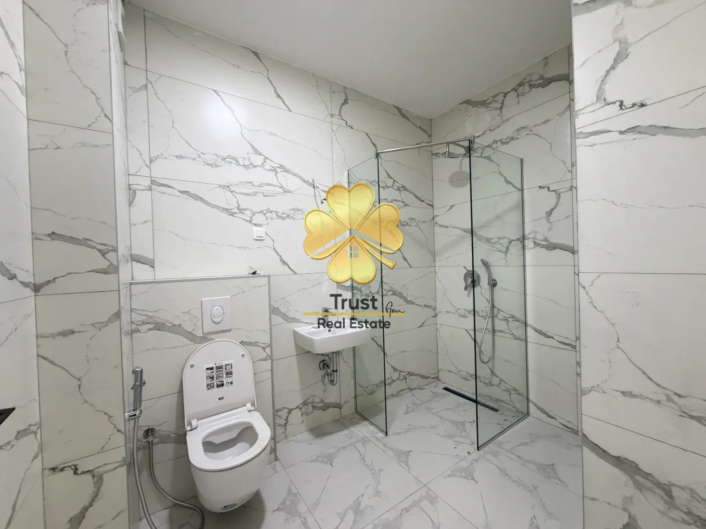 Modern bathroom with a walk-in shower and marble-effect tiles.