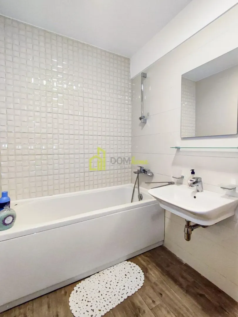 Bathroom equipped with a bathtub, washbasin, and mirror.