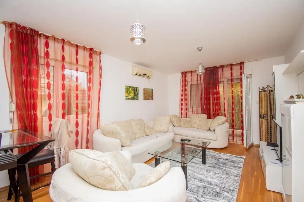 Bright living room with sofas and a glass table.