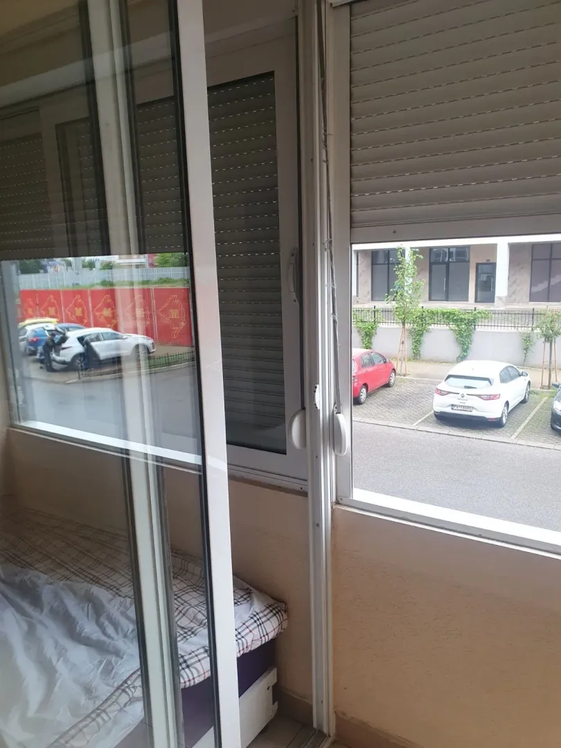 View from a glazed balcony overlooking the parking lot and street.